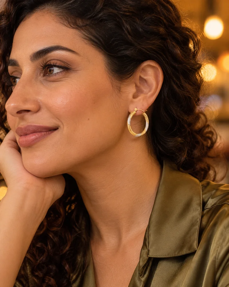 Textured mixed-gold hoop earrings worn naturally in an evening look