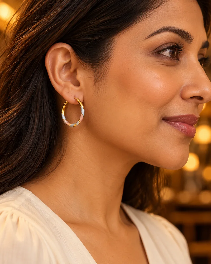 Tri-color gold hoop earrings worn naturally in an evening look